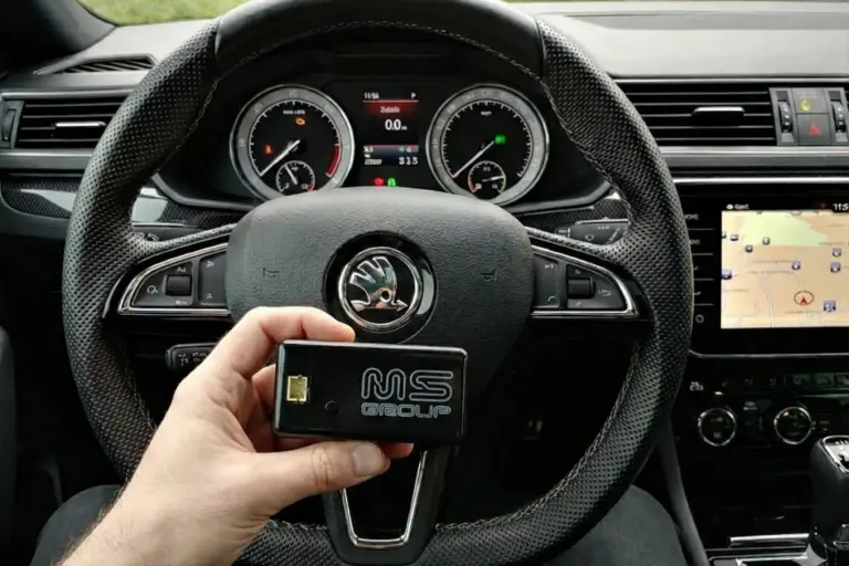 DPF Control za vozila Škoda, držan v roki na ozadju armaturne plošče avtomobila