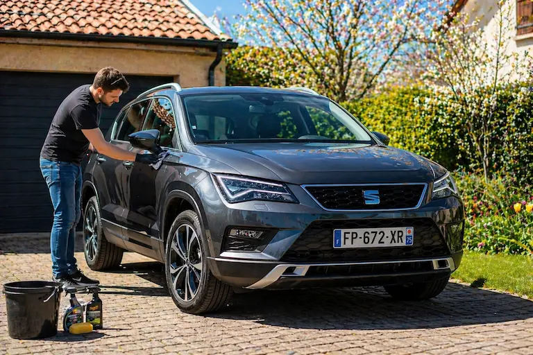Hombre cuidando su SEAT TDI como parte del mantenimiento de primavera de su vehículo diésel